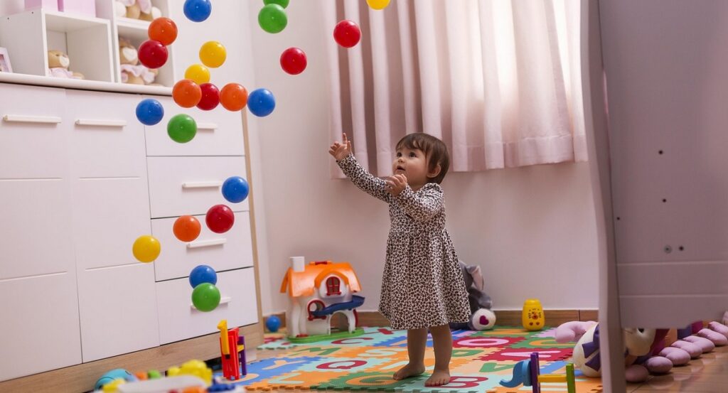 Zabawki dla dziecka - dziewczynka z kolorowymi piłkami